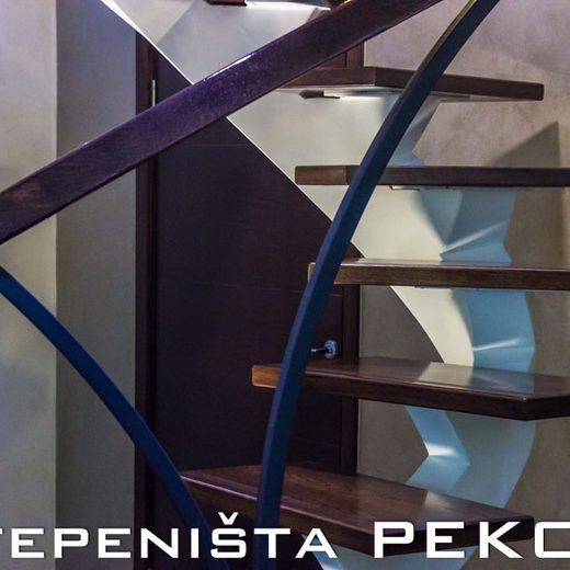Detalj spajanja tamnog zakrivljenog rukohvata i bele kaskadne nosive grede na elipsastom stepeništu