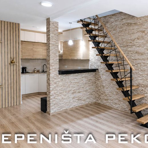 Jednoosovinske metalne stepenice u otvorenom dnevnom boravku sa drvenim gazištima i mrežastom zaštitnom ogradom